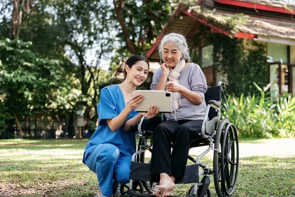 Woman Blue Uniform Helping Elderly Woman Wheelchair Fotografia Stock