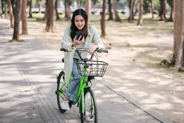 Woman Riding Green Bicycle Basket Front She Looking Her Cell Foto Stock