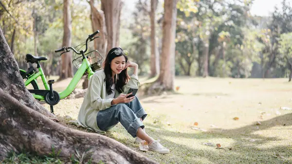 Woman Sitting Grass Next Green Bicycle She Looking Her Phone Fotografia Stock