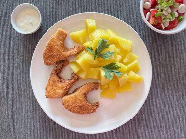 Kızarmış patatesli veranda, domates salatası ve yoğurt sosu. Tepeden çekim.