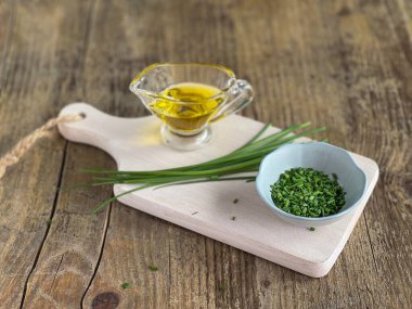 Kesme tahtasında taze taze organik soğan ve zeytinyağı var. Seçici odak.