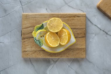 Tahta kesme tahtasında yarım limon ve gri arka plan. Tepeden çekim.
