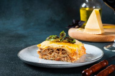 Koyu arkaplanda lezzetli bir lazanya. Geleneksel İtalyan lazanyası. İtalyan yemeği. Lazanyayı kapat. Bolonez sosu. Sos haline geldi. Hala yiyecek dolu bir hayat. Ev yapımı et lazanyası.