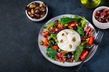 Burrata, krema ve inek sütünden yapılmış İtalyan taze peyniri. Domatesli ve salatalı Burrata salatası. Sağlıklı beslenme konsepti. Keto diyet salatası