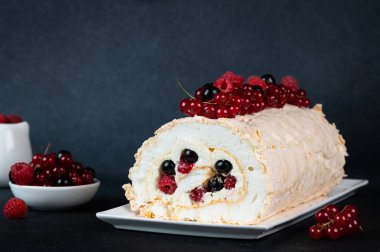 Meringue roll cake with cream and berries. Roulade, summer dessert. Confectionery dessert