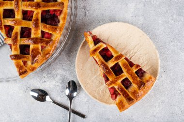 Piece of Cherry Pie with a Flaky Crust on light background. Top view. American pie. Cherry dessert. Flatlay. Cherry filling.