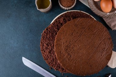 Homemade round chocolate sponge cake or chiffon cake. Sponge cake ingredients: eggs, flour and cocoa. Chocolate biscuit.