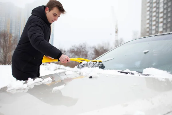 Młody Facet Czyści Śnieg Szczotką Samochodu Mężczyzna Zajmuje Się Samochodem — Zdjęcie stockowe