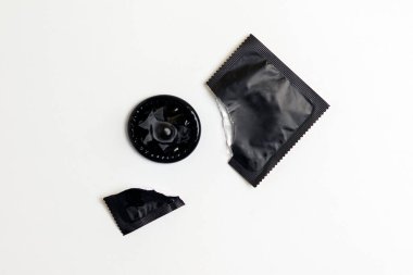 Beyaz arka planda siyah prezervatif paketi, güvenli seks konsepti