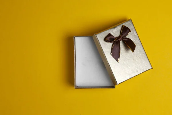 golden gift box open lies on a yellow background, a small empty gift, template