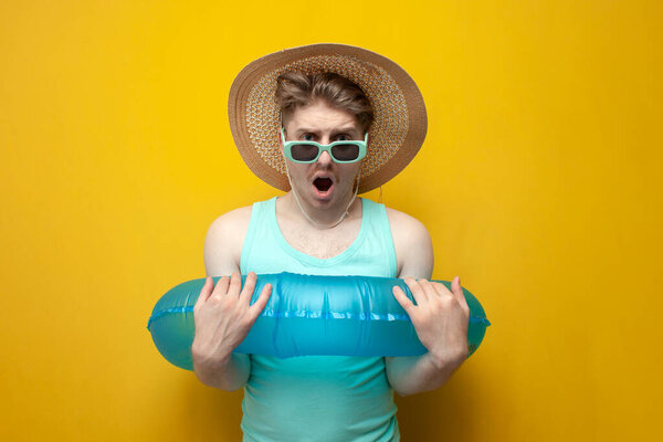 Молодой парень с надувным плавательным кольцом связан и ограничен в действии и свободе, человек в отпуске летом ограничен и шокирован, концепция