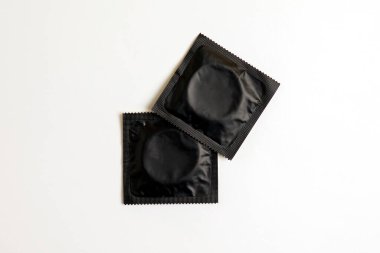 two black condom on white background, top view, safe sex concept