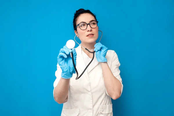 Ung Flicka Läkare Uniform Använder Stetoskop Och Lyssnar Blå Bakgrund — Stockfoto