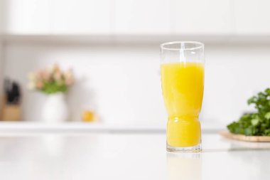 Portakal suyu ile dolu bardaklar beyaz modern mutfakta, sağlıklı yiyecek ve içecek konsepti, kopyalama alanı