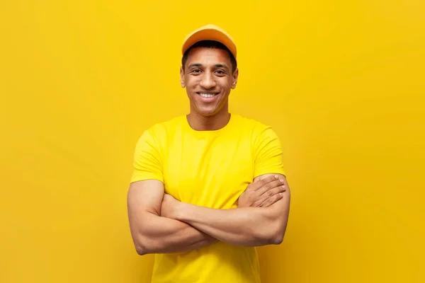 Young African American Delivery Man Yellow Uniform Stands His Arms — Stock Photo, Image