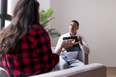 Psikoterapide seans, Afrika kökenli Amerikalı erkek psikolog kadın hastaları dinler ve panoya sorunlar yazar, kız sorunları anlatır ve psikiyatristlerle konuşur.