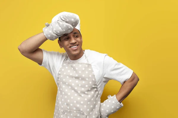 아프리카 미국인 제빵사가 앞치마를 장갑을 노란색외진 배경의 복제품 공간을 제복을 — 스톡 사진