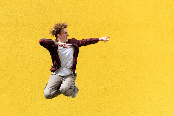 Jonge Man Student Springt Tegen Achtergrond Van Geel Geïsoleerde Muur — Stockfoto