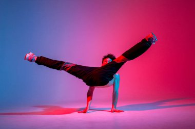 Siyah elbiseli genç dansçı neon ışıkta dans ediyor, adam kırmızı mavi kulüpte hip hop hareketi yapıyor.