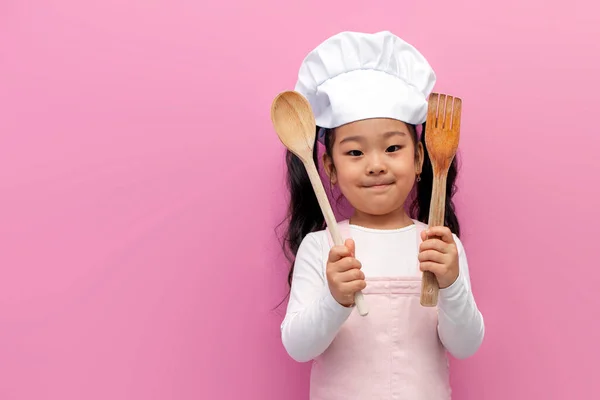 Pequena Asiática Menina Chef Uniforme Segurando Itens Cozinha Rosa Isolado — Fotografia de Stock