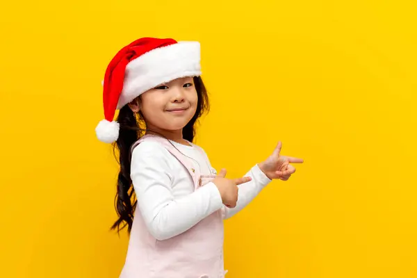Sarı Arka Planda Noel Baba Şapkası Takan Reklam Veren Küçük — Stok fotoğraf