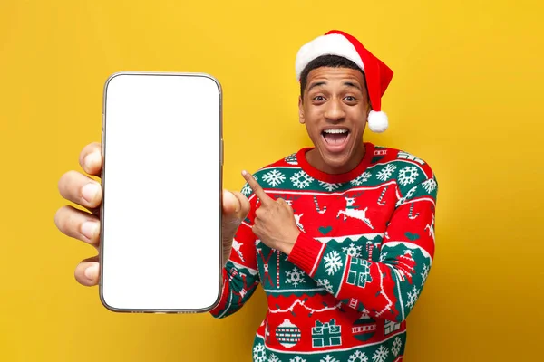 크리스마스 모자를 아프리카계 남자가 배경에 스마트폰 화면을 있습니다 — 스톡 사진