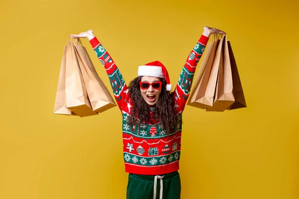 크리스마스 때입는 모자를 여자가 쇼핑백을 배경에 미소를 있습니다 — 스톡 사진