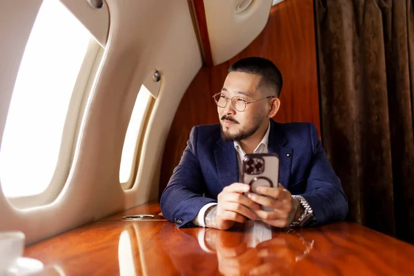 Asiático Exitoso Hombre Negocios Vuela Jet Lujo Privado Utiliza Teléfono — Foto de Stock