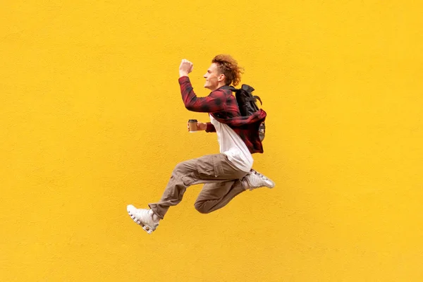 Молодой Веселый Парень Студент Рюкзаком Кофе Быстро Бежит Воздухе Прыгает — стоковое фото