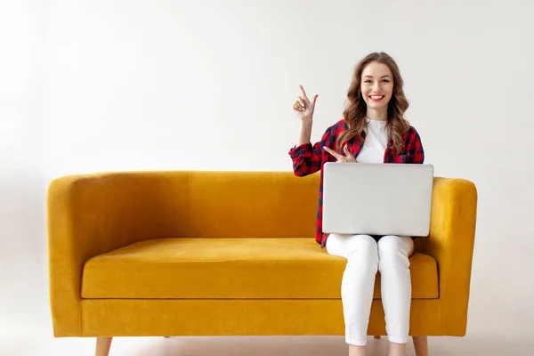 Young Cute Girl Uses Laptop Comfortable Soft Sofa Shows Copy — Stock Photo, Image
