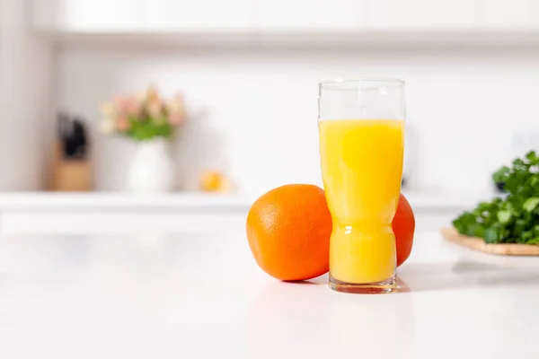 Färskpressad Apelsinjuice Ett Glas Står Nära Apelsiner Ett Vitt Modernt — Stockfoto