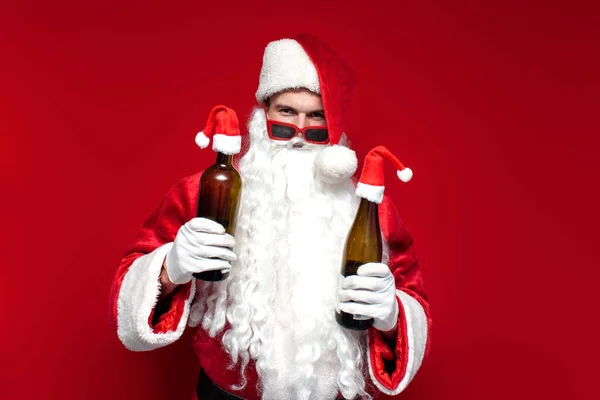 Pijany Mikołaj Kapeluszu Świąteczne Okulary Pije Wino Butelki Czerwonym Tle — Zdjęcie stockowe