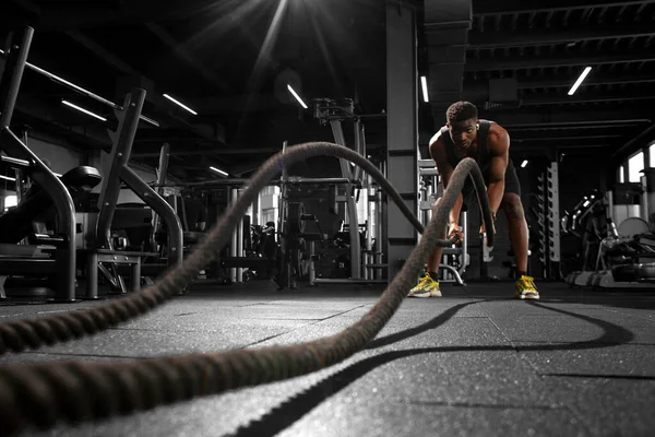 Young Athletic African American Man Trains Ropes Dark Gym Motivated — Stock Photo, Image