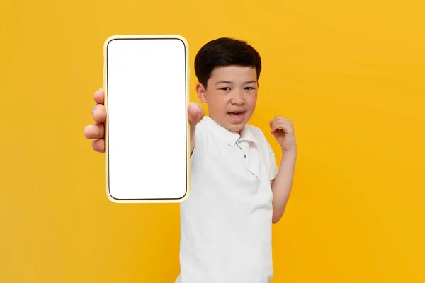 Mały Azjatycki Chłopiec Zwycięzca Pokazać Pusty Ekran Smartfona Żółtym Tle — Zdjęcie stockowe