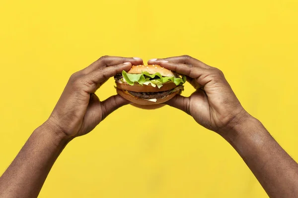 Αφροαμερικανοί Άνδρες Χέρια Κατέχουν Νόστιμο Burger Κίτρινο Απομονωμένο Φόντο Closeup — Φωτογραφία Αρχείου