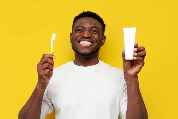 Αφροαμερικάνος Λευκό Οδοντωτό Χαμόγελο Κρατάει Οδοντόβουρτσα Και Οδοντόπαστα Κίτρινο Απομονωμένο — Φωτογραφία Αρχείου