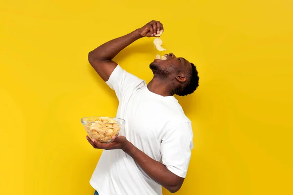 Щасливий Афроамериканський Чоловік Тримає Тарілку Чіпсами Їсть Закуски Картоплі Жовтому — стокове фото