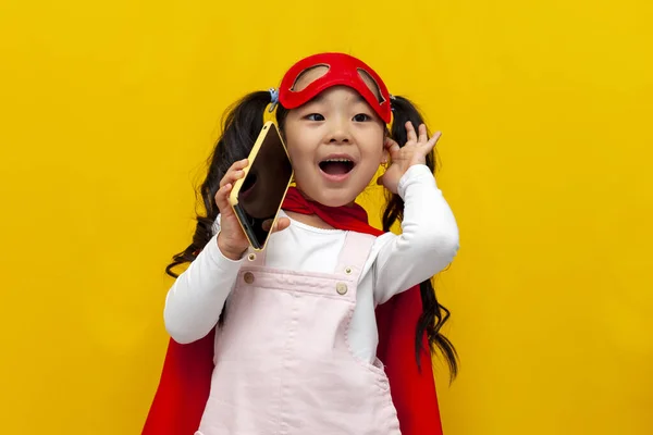 Pequeña Chica Asiática Traje Superman Máscara Está Hablando Por Teléfono — Foto de Stock