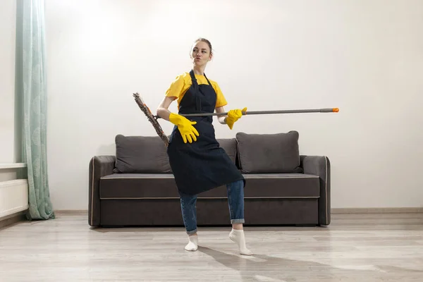 Fröhliche Haushälterin Schürze Und Handschuhen Putzt Häuser Und Tanzt Mit — Stockfoto