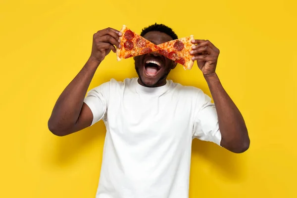 Афроамериканський Чоловік Білій Футболці Тримає Два Шматки Піци Перед Очима — стокове фото