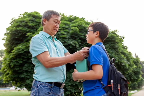 亚洲的老爸爸和儿子一起上学 带着书 韩国的男孩背着背包和眼镜 夏天和老爸爸一起上学 爷爷照顾孙子 — 图库照片
