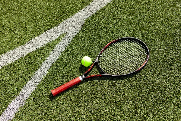 ボール付きのプロテニスラケットは緑のコートにあり 床にはテニス用具 クローズアップ — ストック写真
