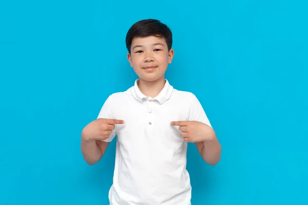 Beyaz Tişörtlü Küçük Asyalı Çocuk Mavi Arka Planda Kendini Işaret — Stok fotoğraf