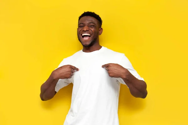 Χαρούμενος Αφροαμερικάνος Λευκό Μπλουζάκι Δείχνει Χέρια Του Στο Κίτρινο Απομονωμένο — Φωτογραφία Αρχείου