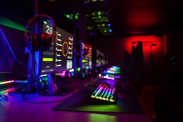 霓虹灯照明中的计算机俱乐部 显示器 椅子和耳机 网络游戏玩家的装置和设备 — 图库照片