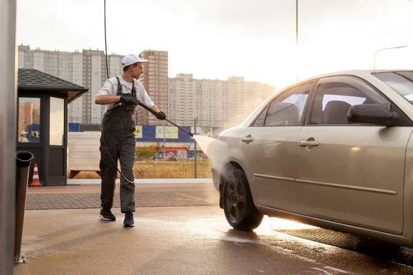 Mladý Chlap Uniformě Mytí Aut Pracovník Myje Auto Vodou Hadice — Stock fotografie