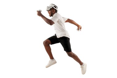 Afrika kökenli Amerikalı erkek sporcu sanal gerçeklik gözlükleriyle beyaz arka planda koşuyor, modern VR aygıt atlayışları ve trenler kullanıyor.