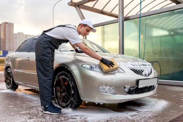 Mladý Muž Uniformě Mytí Aut Pracovník Myje Auto Houbou Pěnou — Stock fotografie