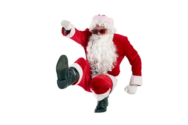 メガネのひげと赤いスーツのサンタクロースは 白い隔離された背景 新年のコンセプトとクリスマスの彼の足で前方に飛びます — ストック写真