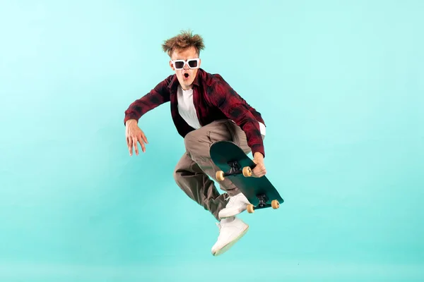 Young Crazy Guy Rides Skateboard Jumps Blue Isolated Background Hipster — Stock Photo, Image